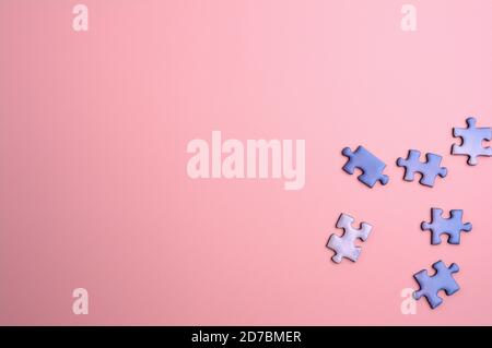 détail de quelques pièces de puzzle bleu sur un rose lisse arrière-plan Banque D'Images