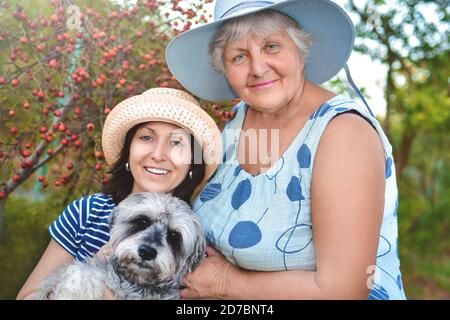 portrait d'une femme âgée heureuse qui embrasse sa fille et son chien. Concept de famille Banque D'Images