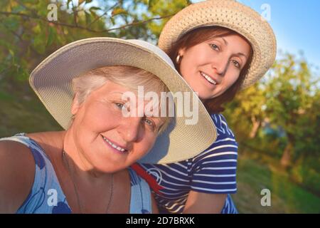 portrait d'une femme âgée heureuse embrassant sa fille et fait le selfie au parc Banque D'Images