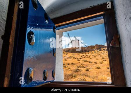 Vue sur un moulin à vent vu à travers un vieux bois fenêtre Banque D'Images