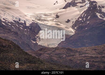 Canal de Sarmiento, Chili - 11 décembre 2008 : gros plan du glacier Amalia au-dessus de la ceinture de roches brunes et de feuillage vert. Banque D'Images