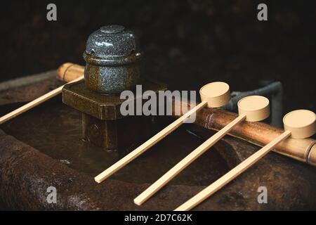 Louche en bois placée sur un bâton de bambou sur un bassin de pierre, Chozuya a utilisé de l'eau pour se laver les mains avant d'entrer dans un temple Shinto au Japon. Placé dans le e Banque D'Images