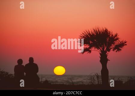 Couple senior vue coucher de soleil ensemble sur la plage de Naples, Floride Banque D'Images