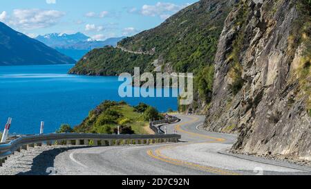 Route sinueuse le long de la falaise et le lac de montagne paysage dans Queenstown, Nouvelle-Zélande Île du Sud. Travel et voyage sur la route en été. Banque D'Images