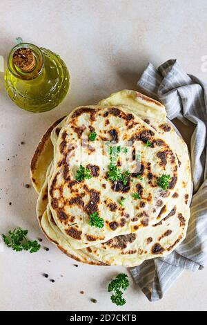 Pain plat traditionnel indien fait maison avec du persil frais et de l'huile d'olive. Chapati, rôti ou pain plat indien naan croustillant. Banque D'Images