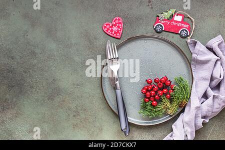 Table de Noël avec décorations de fête sur fond de béton vert avec espace pour les copies. Arrière-plan des vacances. Vue de dessus, plan d'appartement. Banque D'Images