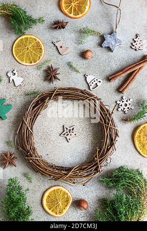 Composition de Noël. Couronne de Noël faite à la main avec jouets de Noël en bois, tranches d'orange séchées et épices. Vue de dessus, plan d'appartement. Banque D'Images