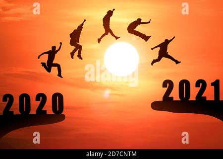 Groupe silhouette de jeunes gens sautant entre 2020 et 2021 années avec beau coucher de soleil à la mer-utilisation pour l'année de nouvelles et des concepts pour les entreprises et ta Banque D'Images