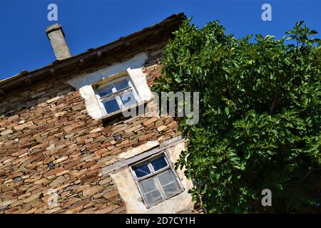 Bulgarie et vues de jolis et petits villages pendant la journée lumineuse.Old style maison de village faite de briques rouges et mut. Arbres verts à côté du millésime Banque D'Images