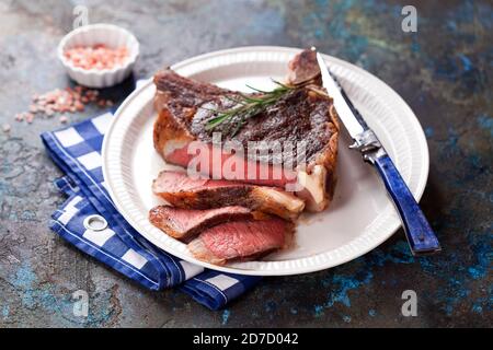 Bifteck de cowboy grillé ou oeillet de côtes tranché sur une assiette, mise au point sélective Banque D'Images