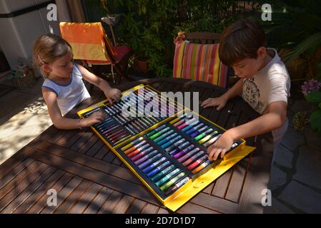 Frère et soeur dessin avec des marqueurs de couleur sur la terrasse  Banque D'Images