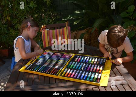 Frère et soeur dessin avec des marqueurs de couleur sur la terrasse  Banque D'Images