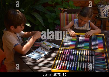 Frère et soeur dessin avec des marqueurs de couleur sur la terrasse  Banque D'Images