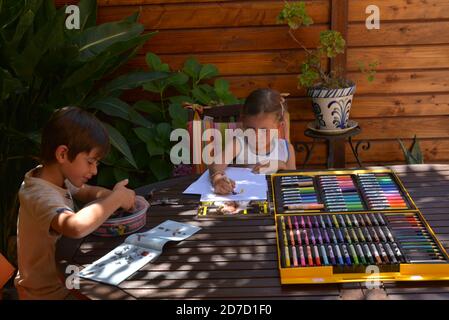 Frère et soeur dessin avec des marqueurs de couleur sur la terrasse  Banque D'Images