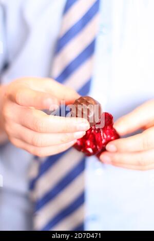 Les enfants se déballer Quality Street Strawberry délient chocolat sucré, gros plan Banque D'Images