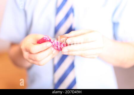 Enfants déballer Quality Street Pink fudge chocolat doux, gros plan Banque D'Images