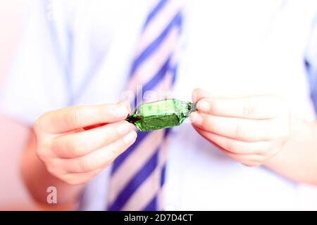 Désemballage d'enfant chocolat au chocolat Quality Street Choc Block enveloppé dans un emballage, gros plan Banque D'Images