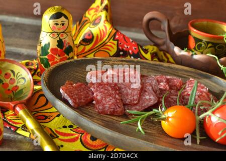 Planche à découper avec saucisse de salami en tranches sur fond de bois Banque D'Images