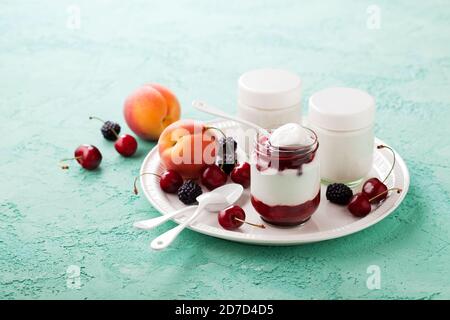 Yaourt à la noix de coco fait maison dans des pots en verre avec baies et fruits frais, foyer sélectif Banque D'Images
