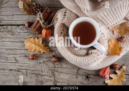 L'appartement d'automne se pose sur une table en bois avec une tasse de thé et des feuilles jaunes sèches. Espace libre pour le texte. Ambiance chaleureuse Banque D'Images