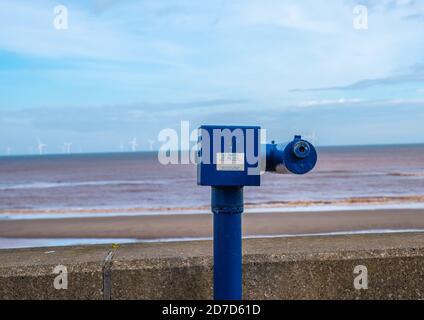 Télescope à pièces sur le front de mer à Withhernsea avec vue sur le parc éolien off shore au loin. Banque D'Images