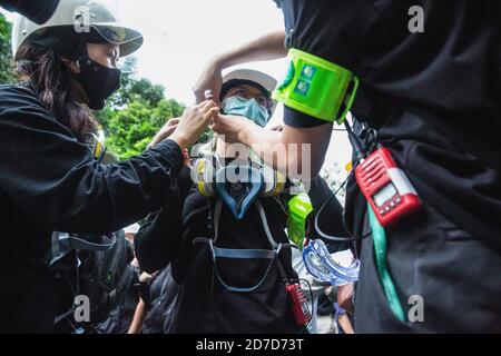 Les gardes volontaires pro-démocratie préparent leur casque avant de briser la ligne de conduite déférée de la police anti-émeute pendant la manifestation. Le pro-démocratie a annoncé le point de rassemblement au Monument de la victoire, marchant vers la Maison du Gouvernement et brisant plusieurs barrières de police dans la rue. À la Maison, la police a préparé des autobus, des fourgonnettes et aussi des camions de canons à eau comme barricades. Les manifestants ont donné un ultimatum au représentant du gouvernement, le premier ministre devant démissionner et libérer les manifestants mis en détention. Banque D'Images