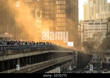 Beyrouth, Liban, 17 octobre 2020. Des rayons du soleil illuminent un nuage de poussière qui s'infiltre dans la brise depuis le site de l'explosion de Beyrouth le 4 août, tandis que des manifestants anti-gouvernementaux défilent du centre-ville de Beyrouth vers une autoroute en face du site de l'explosion pour marquer l'anniversaire de la Thawra libanaise, Un an après le début des manifestations le 17 octobre 2019 Banque D'Images