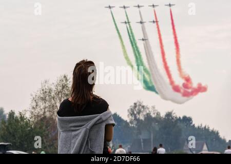 Femme à la recherche de l'équipe acrobatique Frecce Tricolori à Aermacchi MB-339 Voler dans les nuages avec de la fumée à Radom Airshow 2015 Banque D'Images