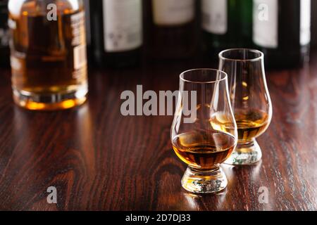 Bouteilles et verre de whisky Spirit brandy sur fond marron foncé Banque D'Images