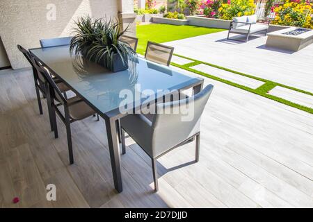 Meubles de patio à l'arrière avec table en verre et six Chaises Banque D'Images