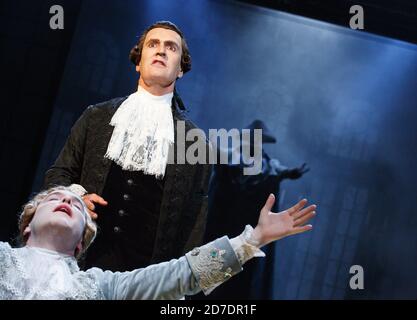 l-r: Joshua McGuire (comme Wolfgang Amadeus Mozart), Rupert Everett (comme Antonio Salieri) avec le Commendatore en arrière-plan dans AMADEUS par Peter Shaffer au Festival Theatre de Chichester, West Sussex, Angleterre 18/07/2014 design: Simon Higlett éclairage: Tim Mitchell directeur: Jonathan Church Banque D'Images