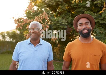 Portrait de père senior relaxant avec un fils adulte dans le jardin À la maison Banque D'Images