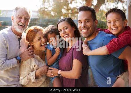 Portrait de la famille hispanique de plusieurs générations se détendant dans le jardin à la maison Ensemble Banque D'Images