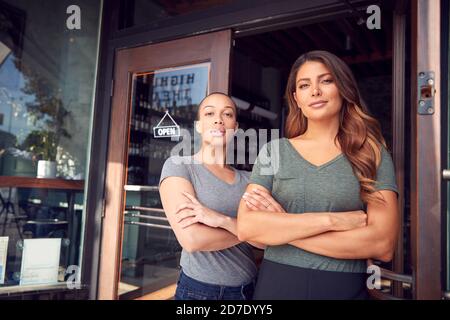 Portrait de deux femmes débutant un nouveau café ou restaurant Entreprise debout à la porte Banque D'Images