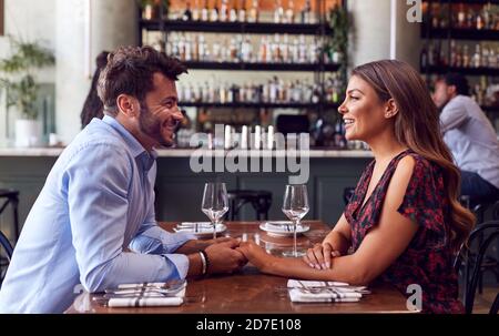 Couple le jour de la Saint-Valentin première date assis à Table in Restaurant Banque D'Images