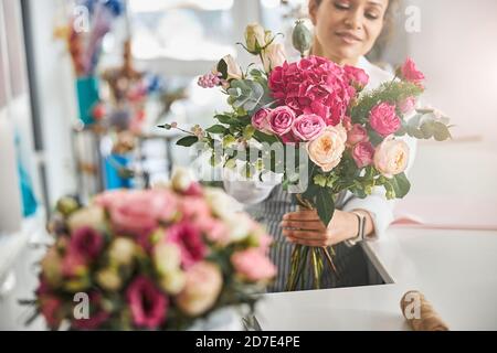 Fleuriste professionnel posé avec une magnifique composition florale Banque D'Images