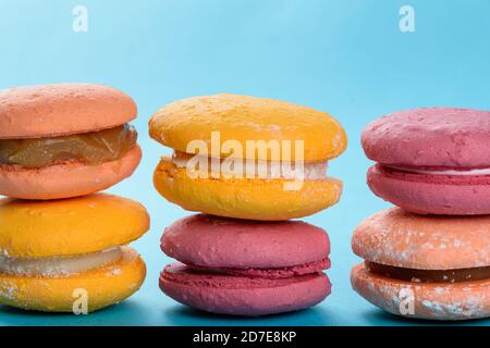 Macarons colorés empilés sur un fond bleu clair. Sucré français avec de la farine d'amande dans sa recette. Banque D'Images