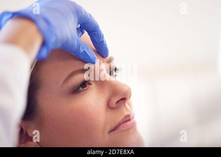 Esthéticienne ou médecin préparant une patiente pour une injection de Botox Banque D'Images