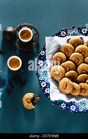 biscuits turcs aux amandes et café sur la table dans des plats traditionnels: une assiette avec un ornement et des tasses de cuivre. temps de thé Banque D'Images