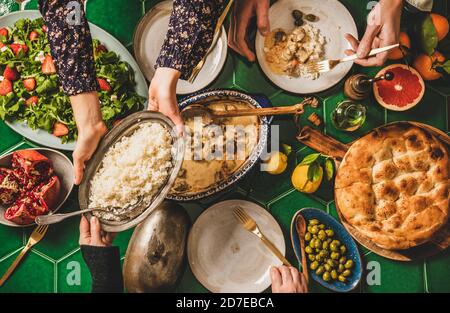 Les gens passent des plats turcs sur la table du dîner de fête, vue du dessus Banque D'Images