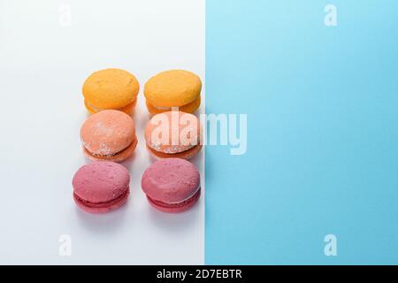 Macarons alignés sur deux cartes de couleur. Création d'une composition avec symétrie avec des lignes parallèles, diagonales et horizontales. Banque D'Images