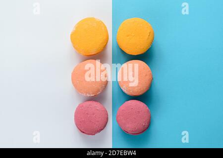 Macarons alignés sur deux cartes de couleur. Création d'une composition avec symétrie avec des lignes parallèles, diagonales et horizontales. Banque D'Images