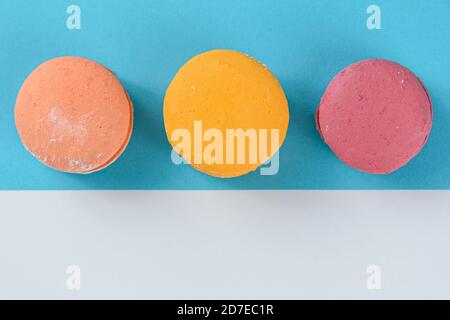 Macarons alignés sur deux cartes de couleur. Création d'une composition avec symétrie avec des lignes parallèles, diagonales et horizontales. Banque D'Images