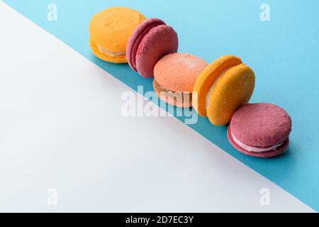 Macarons alignés sur deux cartes de couleur. Création d'une composition avec symétrie avec des lignes parallèles, diagonales et horizontales. Banque D'Images