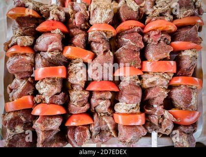 Viande pour barbecue et tomates sur brochettes, saupoudrées de poivre Banque D'Images