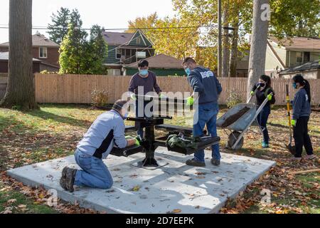 Detroit, Michigan - les bénévoles de CooperStandard installent des tables de pique-nique et font de l'aménagement paysager dans un parc de la ville dans le quartier de Morningside. Le parc i Banque D'Images