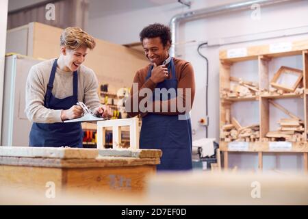 Tuteur avec un étudiant en menuiserie masculine en atelier étudiant pour l'apprentissage À l'université Banque D'Images