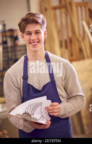 Portrait d'étudiant masculin étudiant pour l'apprentissage de la menuiserie à l'université Avec plans pour escalier Banque D'Images