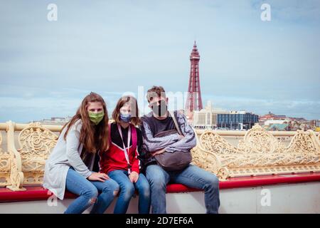 Famille de touristes avec masques de visage à Blackpool Beach Central Pier pendant la pandémie de Covid-19 Banque D'Images