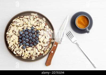 Cheesecake au chocolat maison avec myrtilles et tranches d'amande sur table en bois blanc. Vue de dessus. Banque D'Images